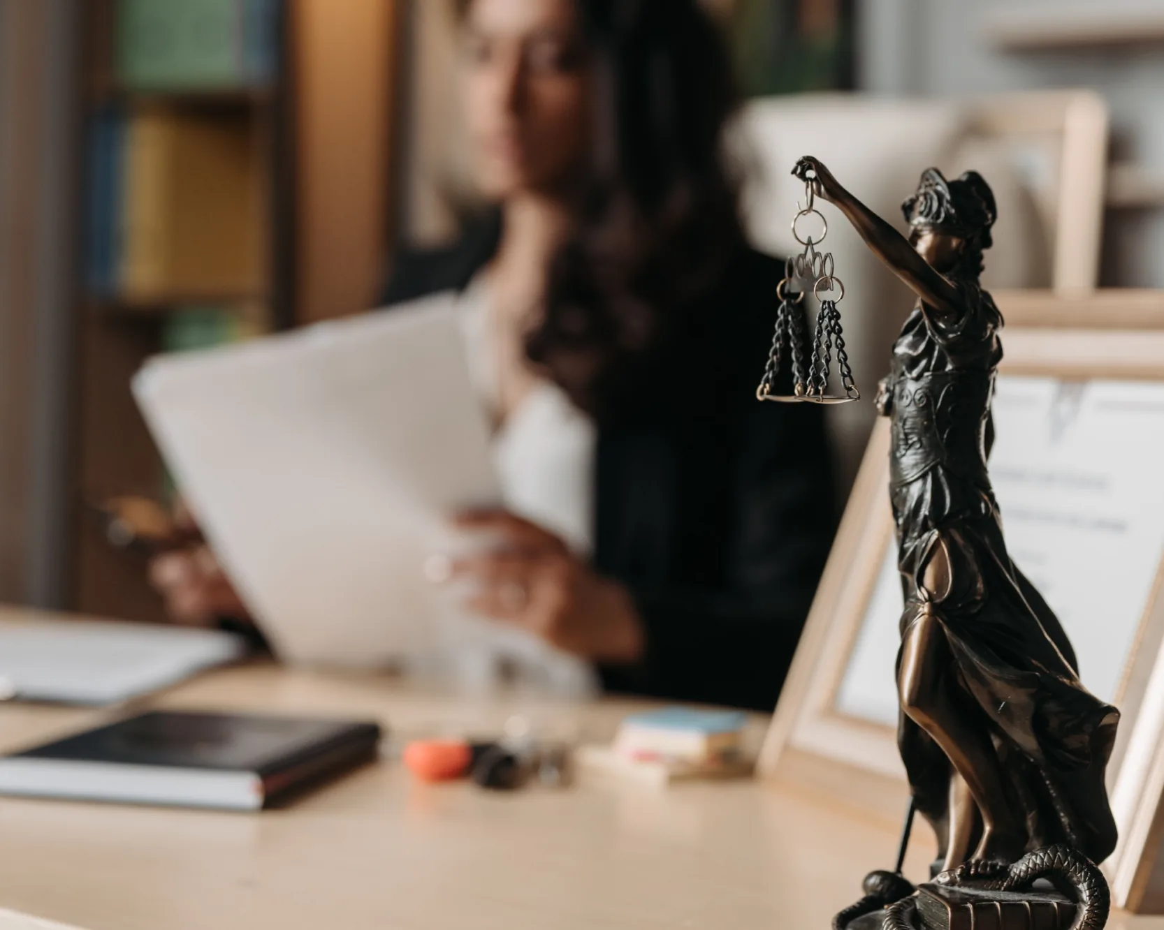 A lawyer at work beside a statue of Lady Justice